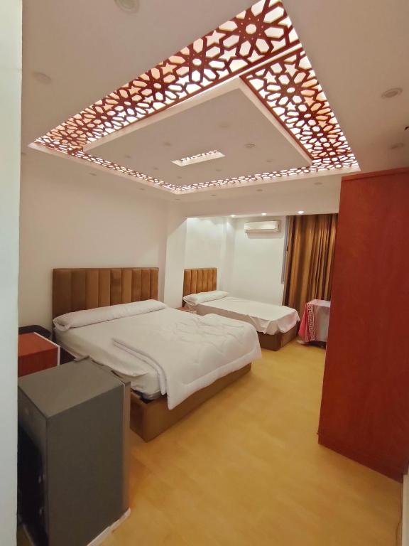 a room with two beds and a television in it at استديوهات Hs2025 in Cairo