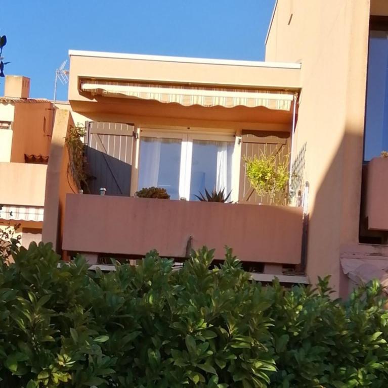 un bâtiment avec un balcon avec des plantes dessus dans l'établissement Résidence ATHENA OREADE, à La Londe-les-Maures