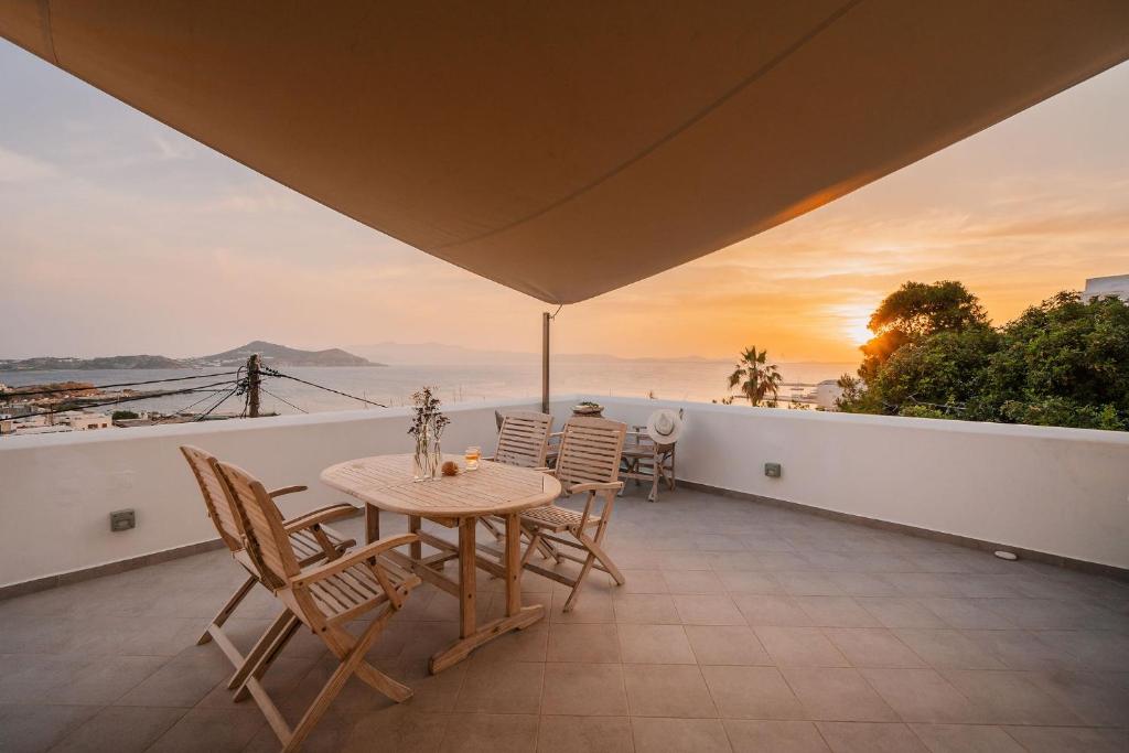 une table et des chaises sur un balcon avec vue dans l'établissement Kastro suite, à Naxos Chora