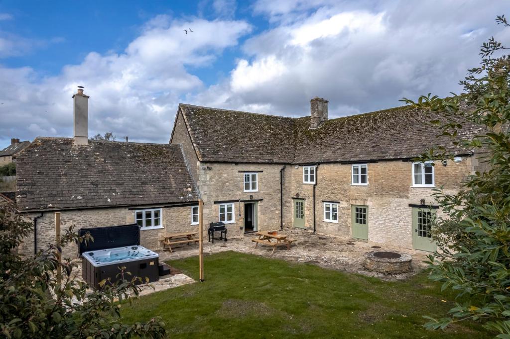 an external view of a large brick house with a yard at Brokenborough Farmhouse in Malmesbury