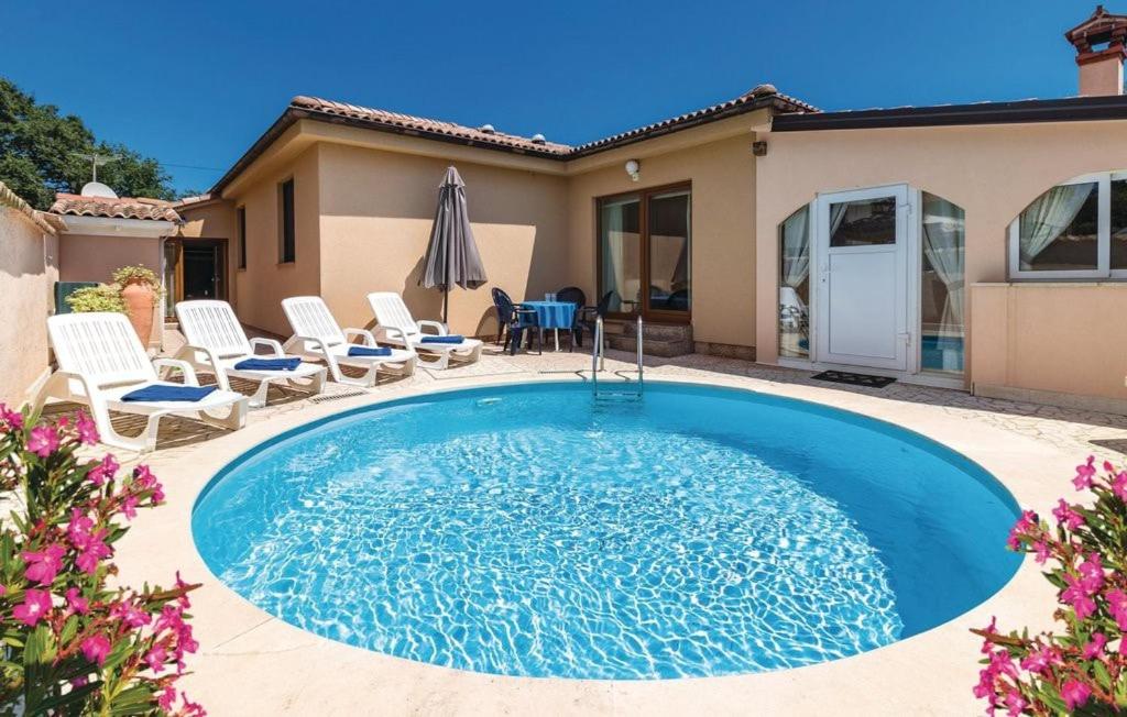 een zwembad in een tuin met stoelen en een huis bij House with pool in Marcana in Marčana