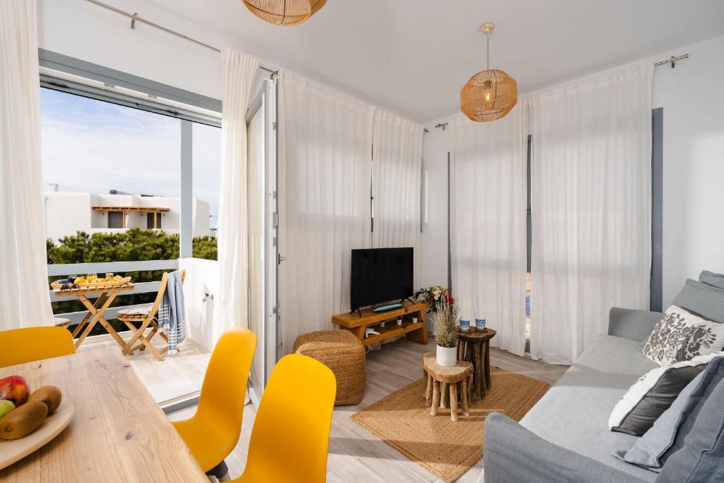 a living room with a couch and a table at Yara Apt 40m from the Beach Jacuzzi & Rooftop in Agia Anna Naxos