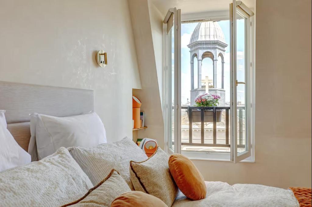 - une chambre avec un lit et une fenêtre avec un bâtiment dans l'établissement La vue du Marais, à Paris