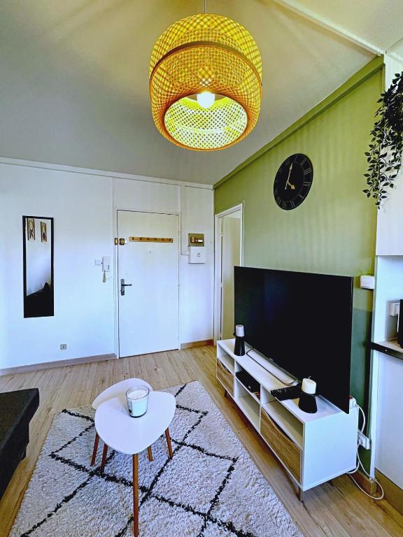 - un salon avec un canapé, une table et un réveil dans l'établissement SOH Rent Strasbourg appartement wifi terrasse, à Strasbourg