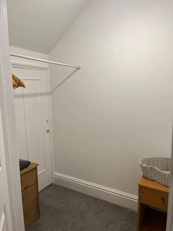 a room with a white wall and a closet at Elysian Fields B&B in Helston