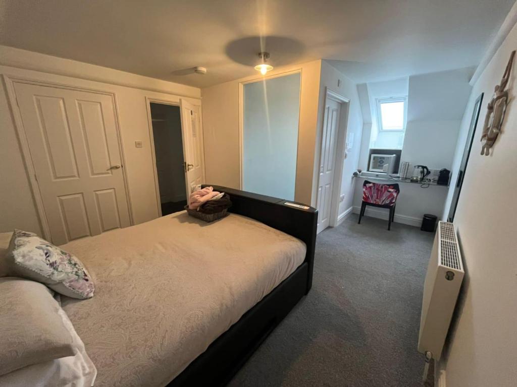 a small bedroom with a bed and a desk at Elysian Fields B&B in Helston
