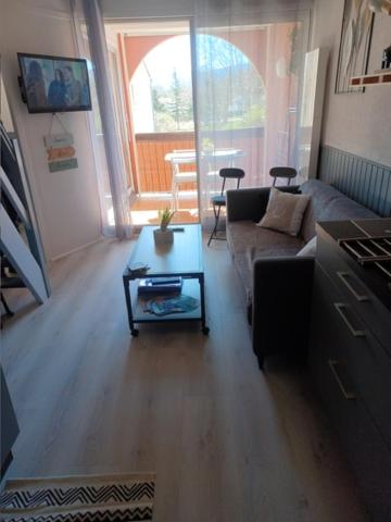 un salon avec un canapé et une table dans l'établissement Appartement en résidence, à Saint-Cyprien