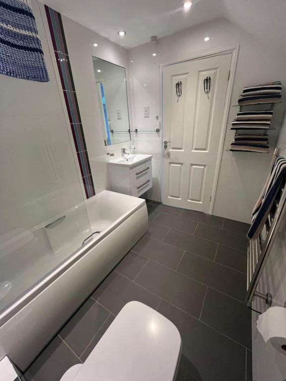 a white bathroom with a toilet and a sink at Elysian Fields B&B in Helston
