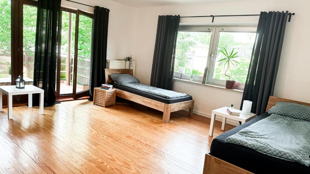 a bedroom with a bed and a futon and windows at Wohnung 6-9P - 3Zi - Aurora Hamburg in Braak