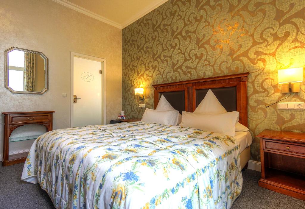 Postel nebo postele na pokoji v ubytování KurparkHotel Warnemünde