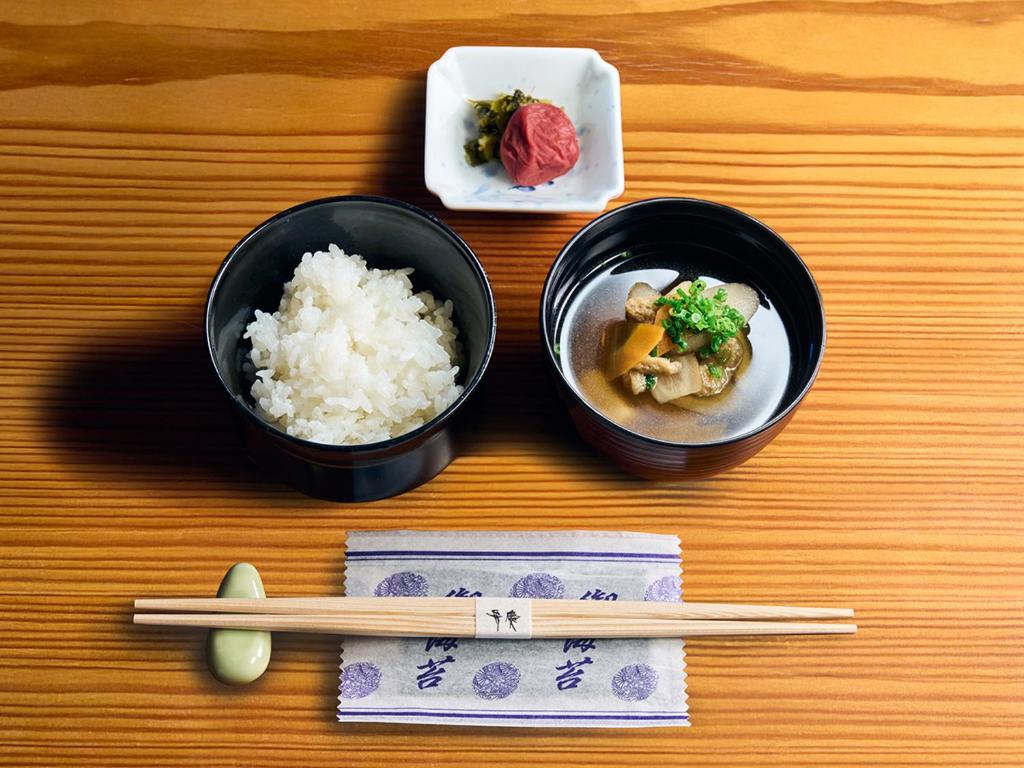 two bowls of rice and chopsticks on a table at Hotel Nikko Kumamoto in Kumamoto