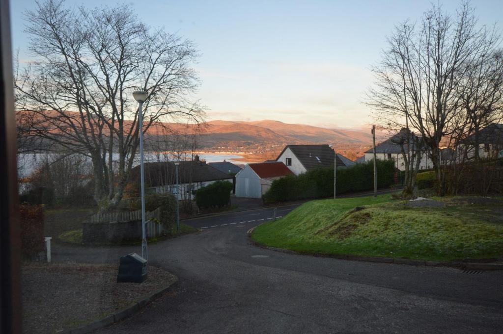 a street in a residential neighborhood with a view of a lake at Pinegrove flat in Fort William