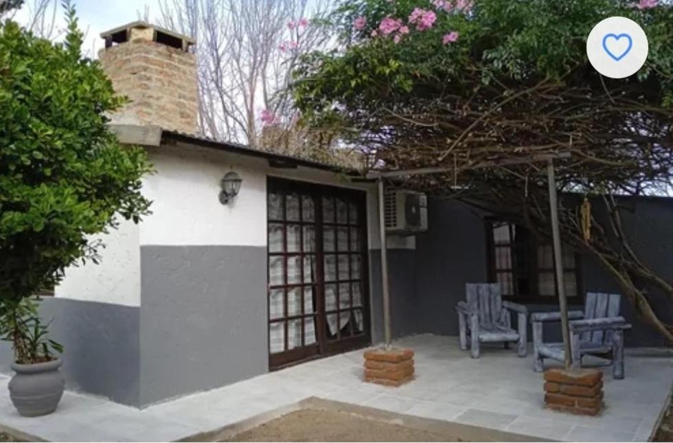 ein Haus mit einer Terrasse mit Tisch und Stühlen in der Unterkunft Agua de rio in San Luis