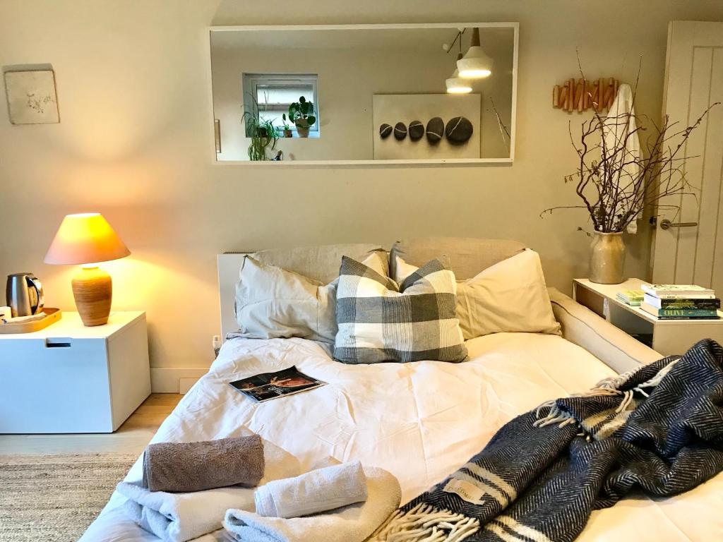a bedroom with a bed with pillows on it at Peaceful Scandi Garden room in Falmouth