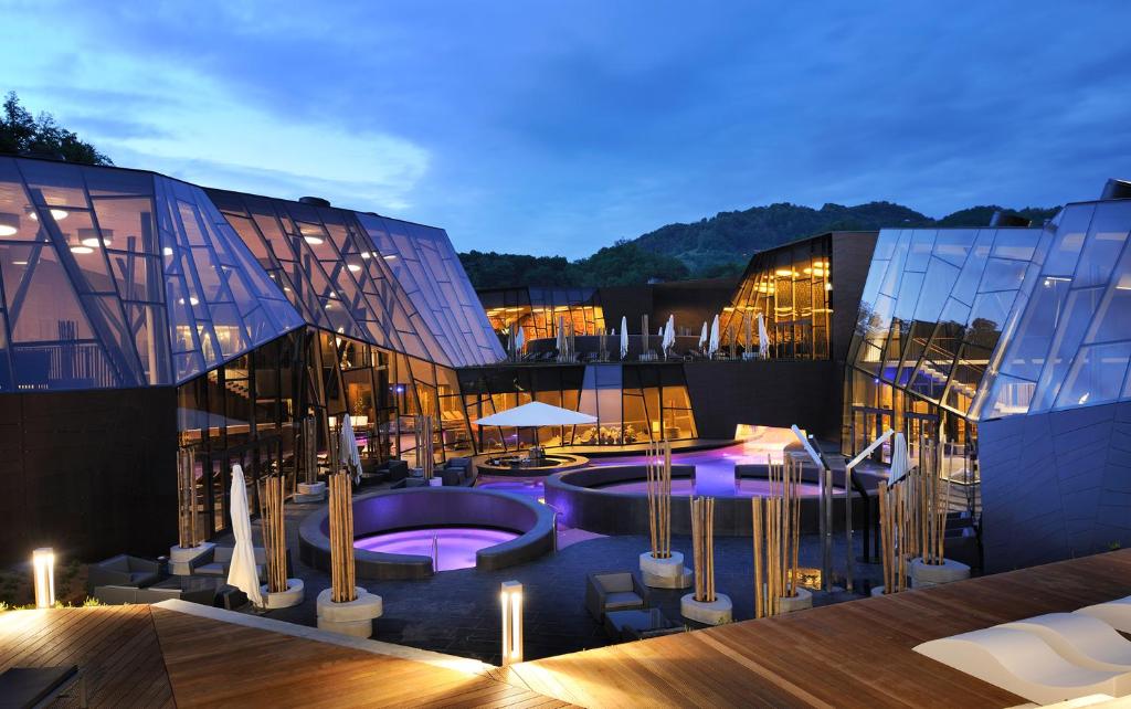 a view of a building with a pool in front of it at F95 AQUALUNA KAMP NATURA PODČETRTEK swimming card not included in Podčetrtek