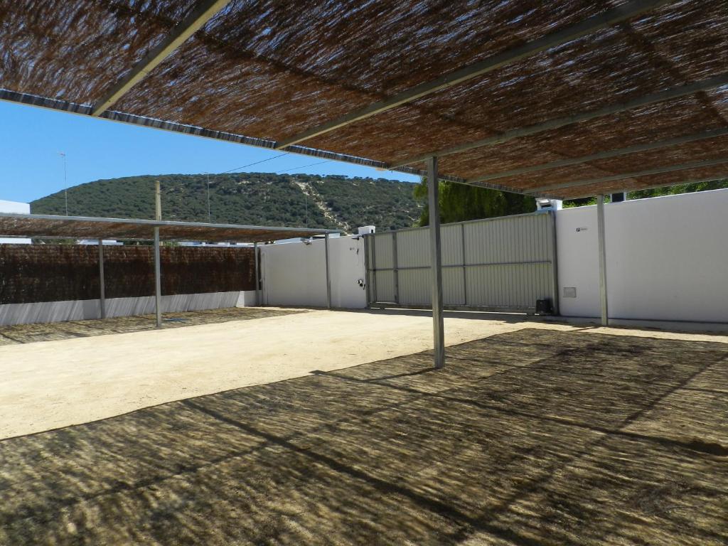 an empty parking lot with a fence and a building at DADA CAÑOS in Los Caños de Meca