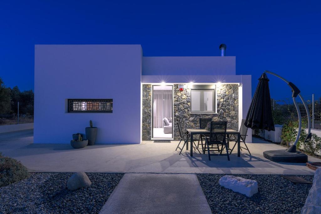 a room with a table and chairs at night at Villa Galini in Haraki