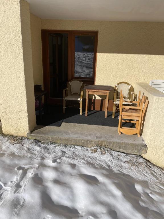 a table and chairs sitting outside of a house at appartement au pied des pistes in Valmorel