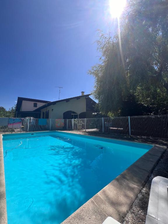une grande piscine bleue dans une cour dans l'établissement Maison 4 chambres avec piscine à Andernos, à Andernos-les-Bains