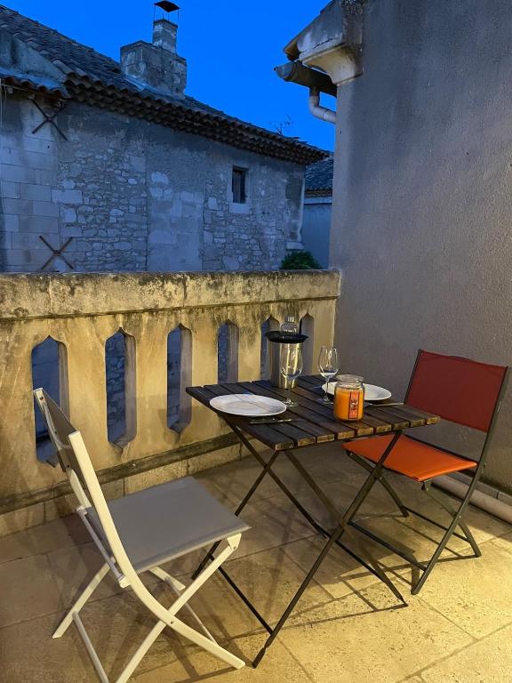 une table et deux chaises assises sur une terrasse dans l'établissement Nostradamus, à Saint-Rémy-de-Provence