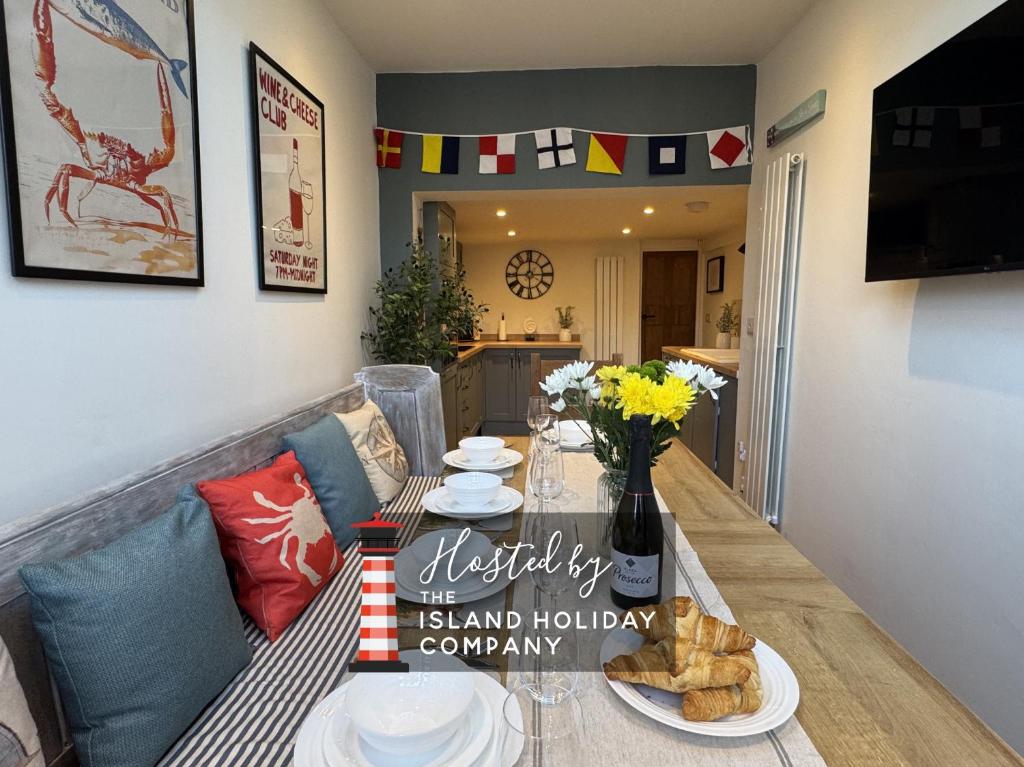 una mesa de comedor con platos de comida. en Driftwood House - Luxury Dog-Friendly Townhouse in Cowes, Steps from Marina, en Cowes