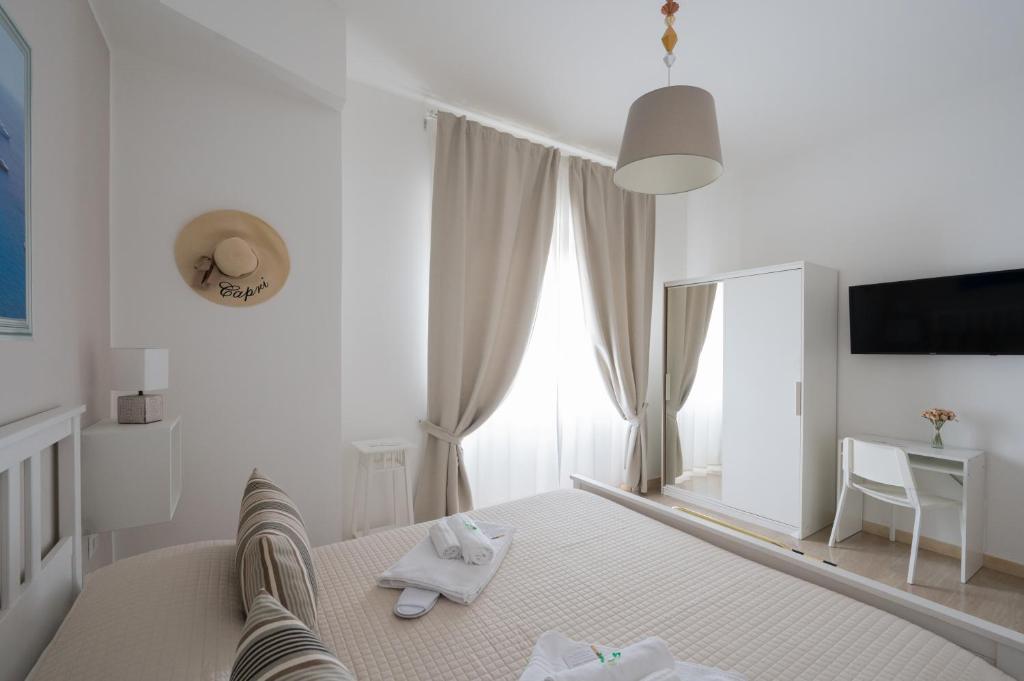 a white bedroom with a bed and a mirror at Panoramic Rooms Salerno in Salerno