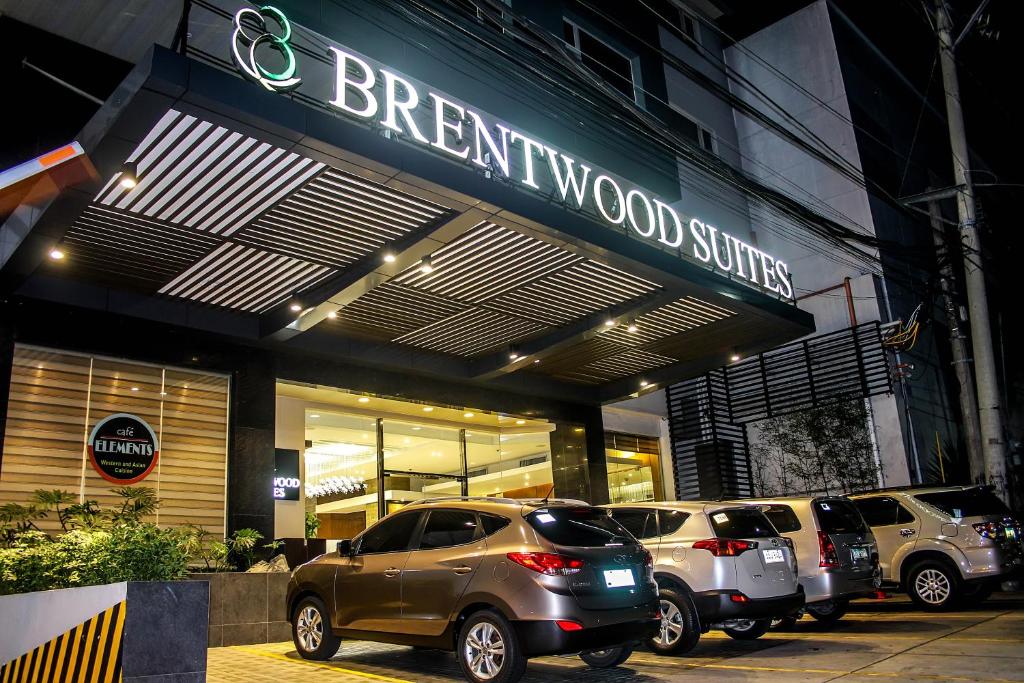 a store front with cars parked in front of it at Brentwood Suites in Manila