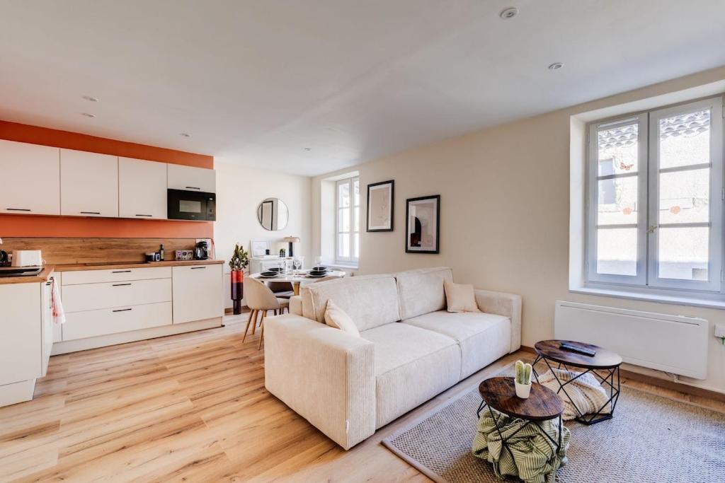 un salon avec un canapé blanc et une cuisine dans l'établissement Chez Seb - Raffiné et Accueillant, à Carcassonne