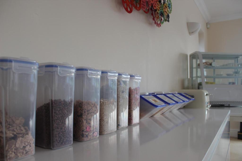 a row of containers of food sitting on a counter at Elysian Fields B&B in Helston