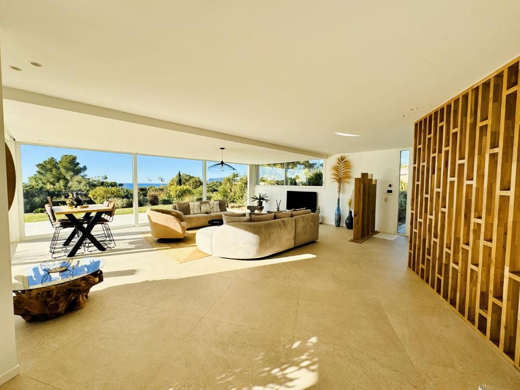 a large living room with couches and a table at Villa d'exception piscine privée et vue mer in Saint-Cyr-sur-Mer