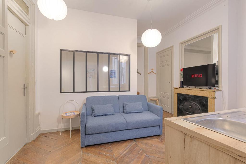 un salon avec un canapé bleu et une télévision dans l'établissement Cosy et Typique à Cordeliers, à Lyon
