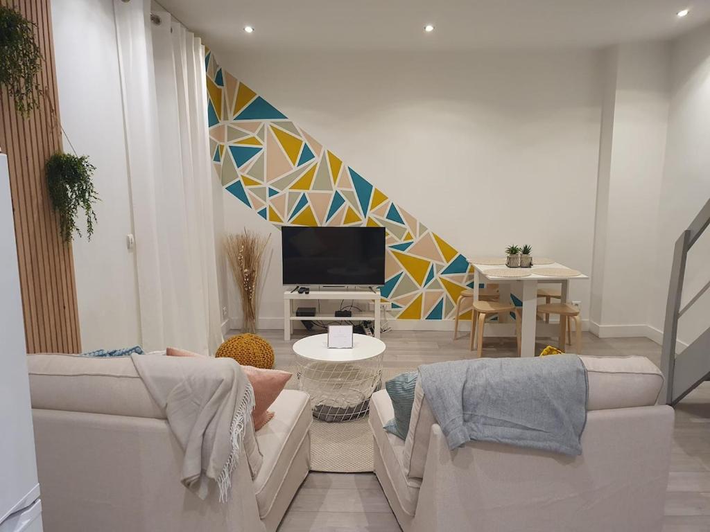 un salon avec deux canapés et une télévision dans l'établissement Appartement Duplex, à Noisy-le-Sec