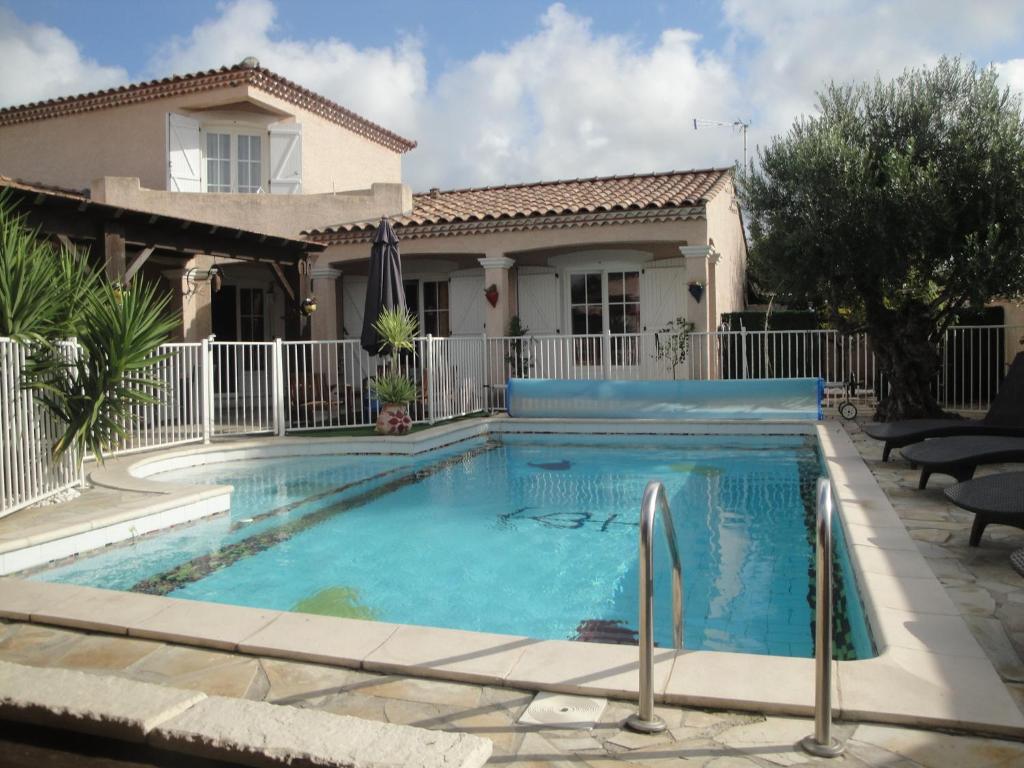 a swimming pool in front of a house at Villa Lombrine in Saint-Laurent-dʼAigouze