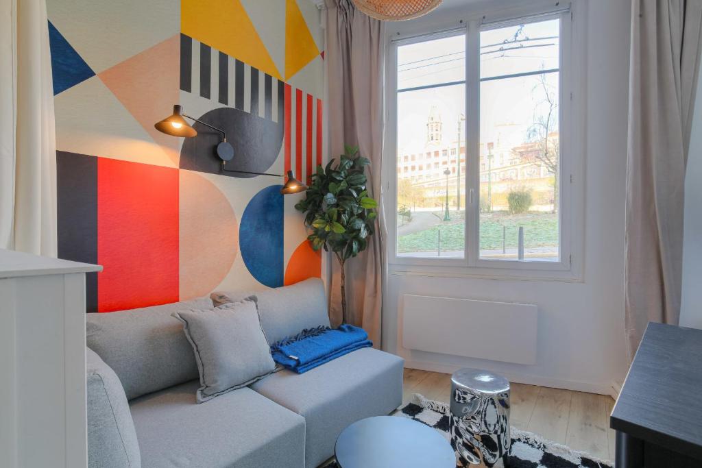 - un salon avec un canapé et un mur coloré dans l'établissement Cosy et Design en hypercentre, à Lyon