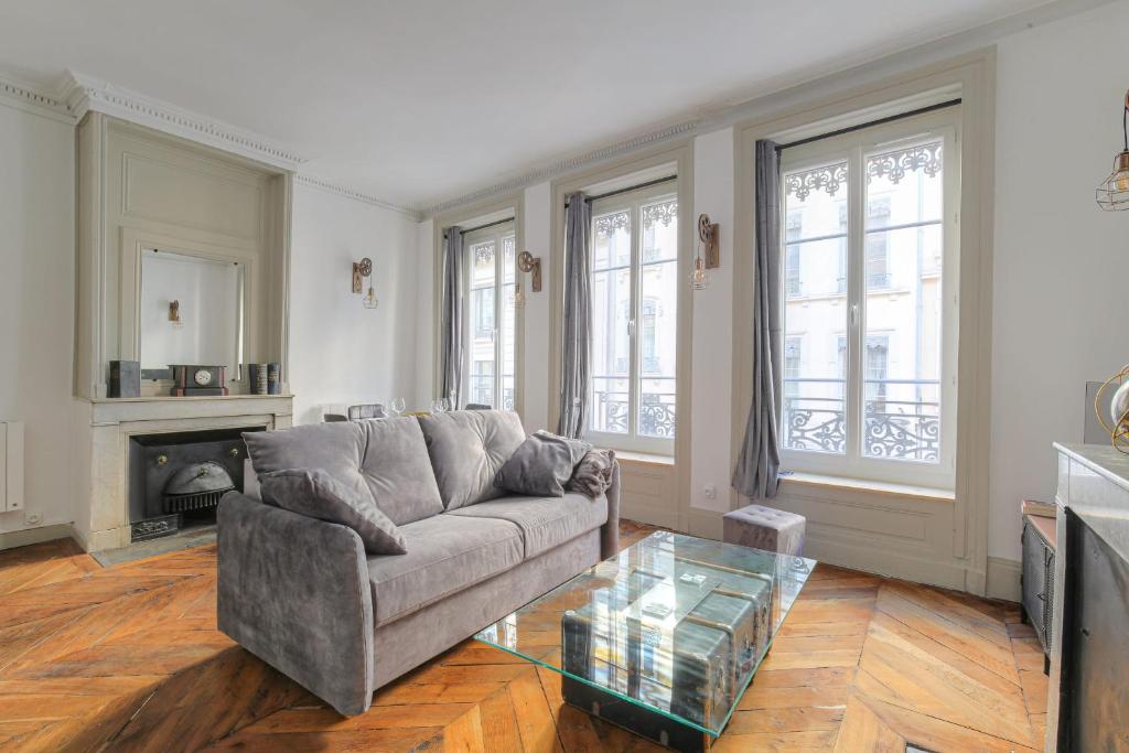 un salon avec un canapé et une table en verre dans l'établissement Caractère et Charmant à Cordeliers, à Lyon