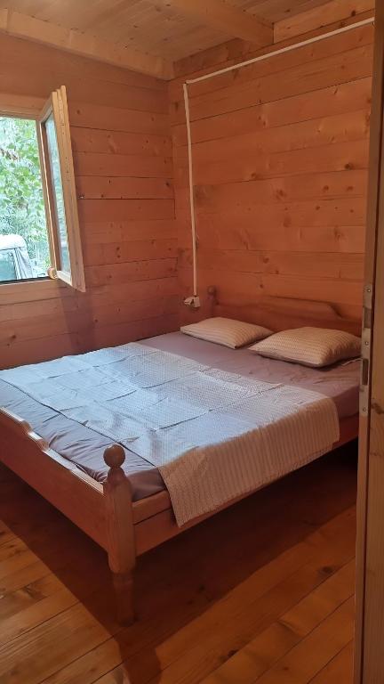 una camera con un letto in una baita di tronchi di comjun a Ada