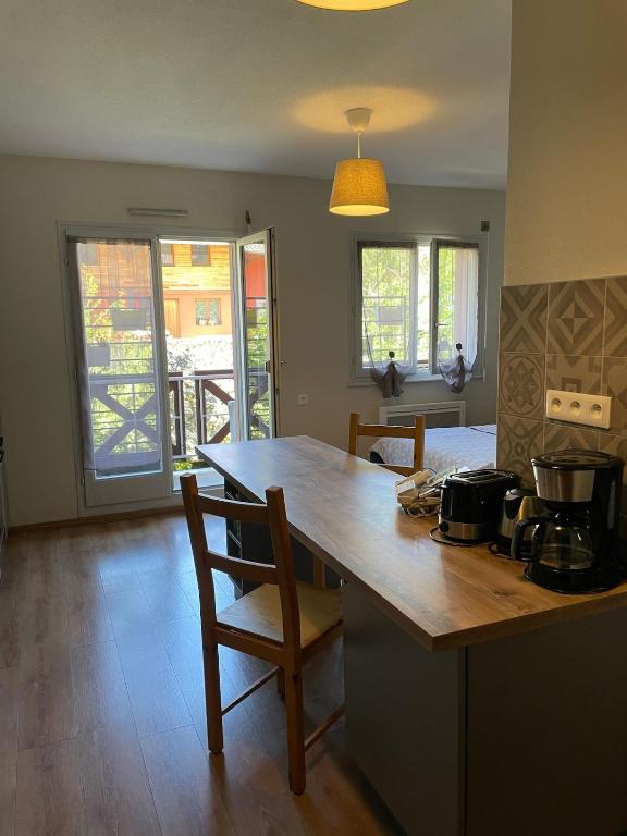 une cuisine avec un comptoir et une table avec des chaises dans l'établissement KAYSERSBERG - Downtown - Balcony and Parking, à Kaysersberg