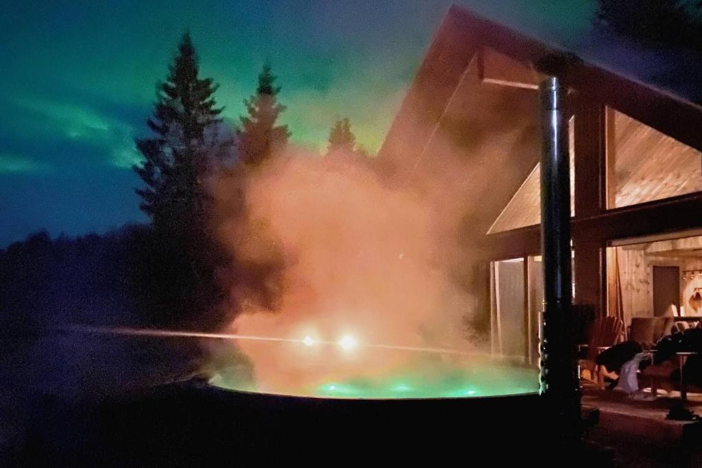 a fire is coming out of a building at Modern Mountain Cabin - Outdoor Hot Tub - 8 Beds in Torpo