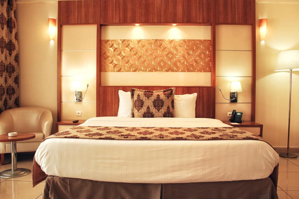 ジブチにあるAtlantic Hotelの大きなベッドと椅子のあるホテルの部屋