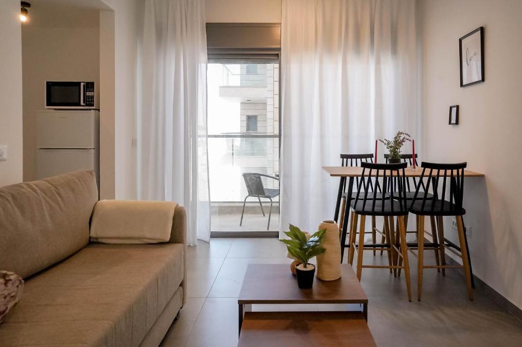 una sala de estar con un sofá y una mesa en Red Sea Icon - by G&P Suites, en Eilat