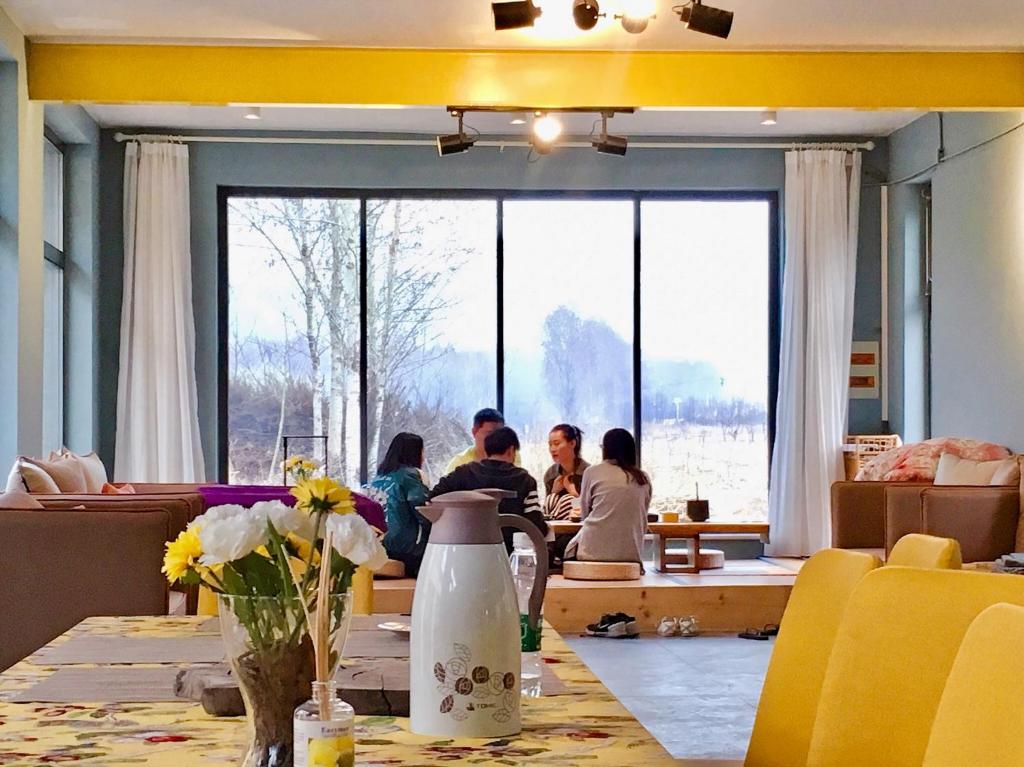 a group of people sitting at a table in a restaurant at Black Stone Family Garden Villa in Yaoqiaoyu