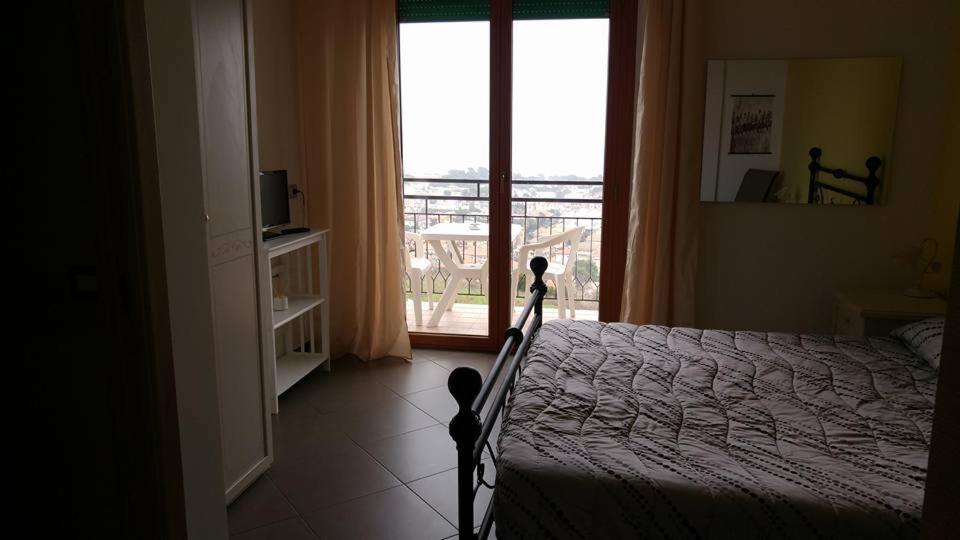 Schlafzimmer mit einem Bett und Blick auf einen Balkon in der Unterkunft Terrazza sul Mare in Giulianova