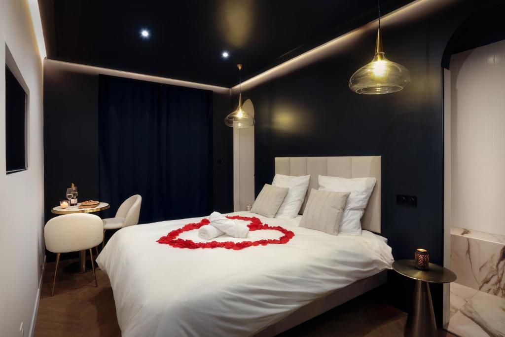- une chambre dotée d'un lit blanc avec une fleur rouge dans l'établissement Luxury Suite Romantic Getaway with Jacuzzi, à Castres