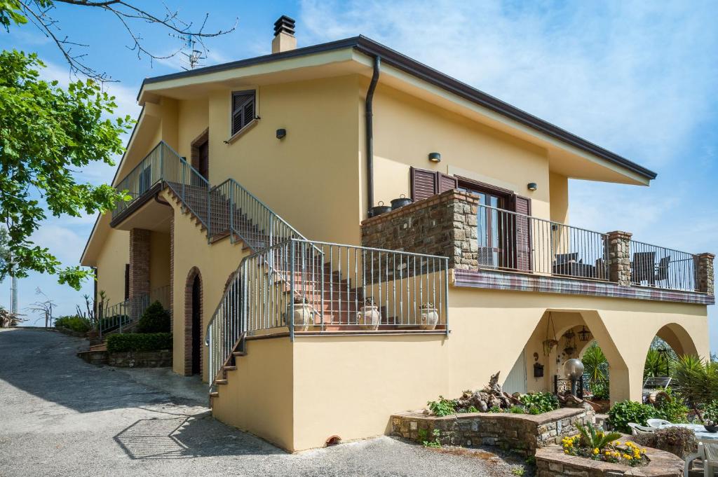 a yellow house with a balcony and stairs at Villa Bernadette in San Mauro Cilento