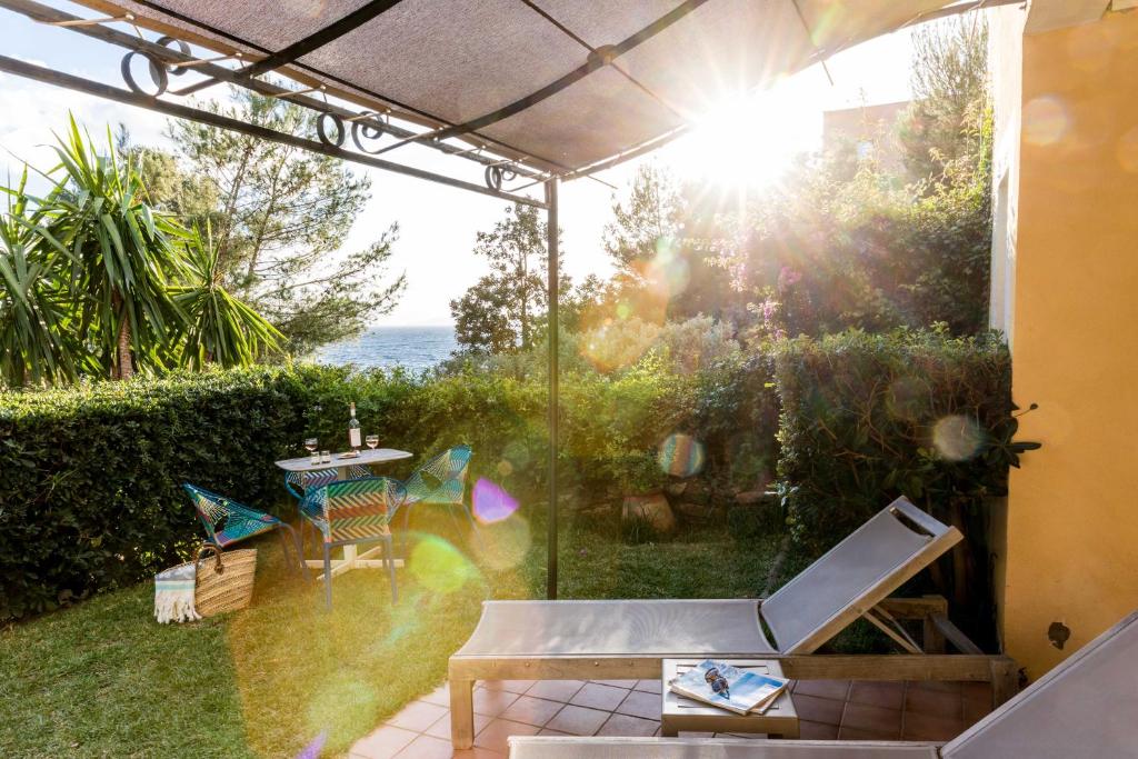 a screened in patio with a view of the ocean at La Résidence du Bailli in Rayol-Canadel-sur-Mer