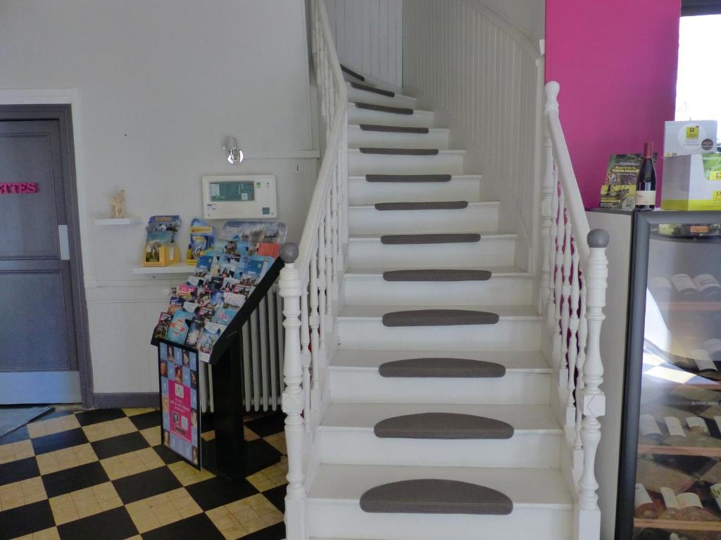 Una escalera en una casa con escaleras blancas en Logis Hôtel Au Croissant, en Buzançais