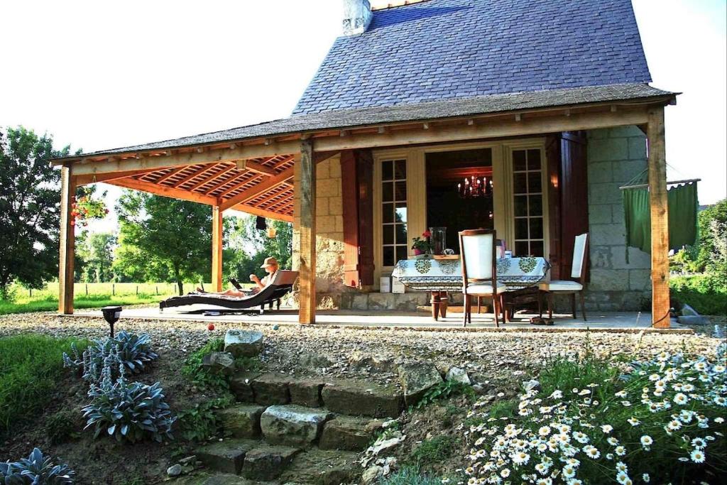 une femme assise sous un pavillon dans un jardin dans l'établissement Le Refuge des Châteaux, à Chinon