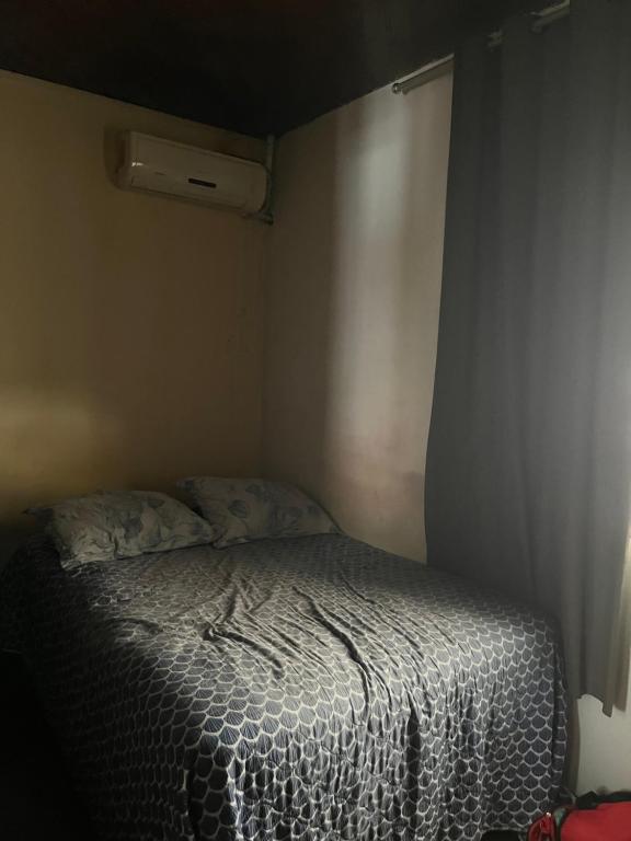 a small bedroom with a bed with a white comforter at Casa para Cop30 in Belém