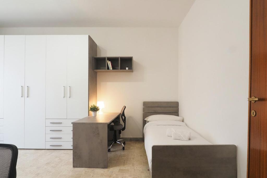 een slaapkamer met een bed en een bureau en een bed en een tafel bij PrimoPiano - Cucchi in Milaan