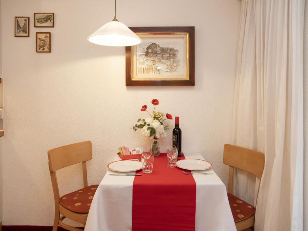 uma mesa com uma toalha de mesa vermelha e branca em Apartment Chalet Abendrot apARTments-2 by Interhome em Grindelwald